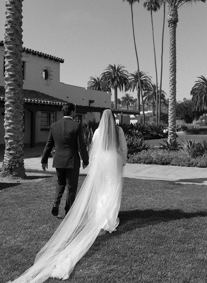 Bride walks down the aisle wearing Unique, luxury, one of a kind long sleeve silk wedding dresses and veil