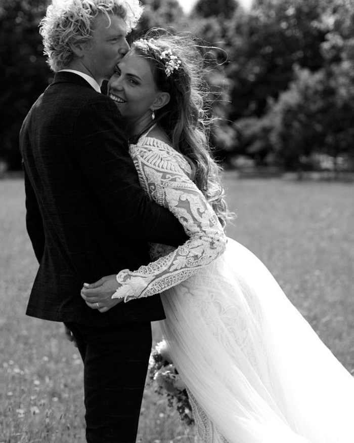 Black and white photo of a couple embracing outdoors on their wedding day
