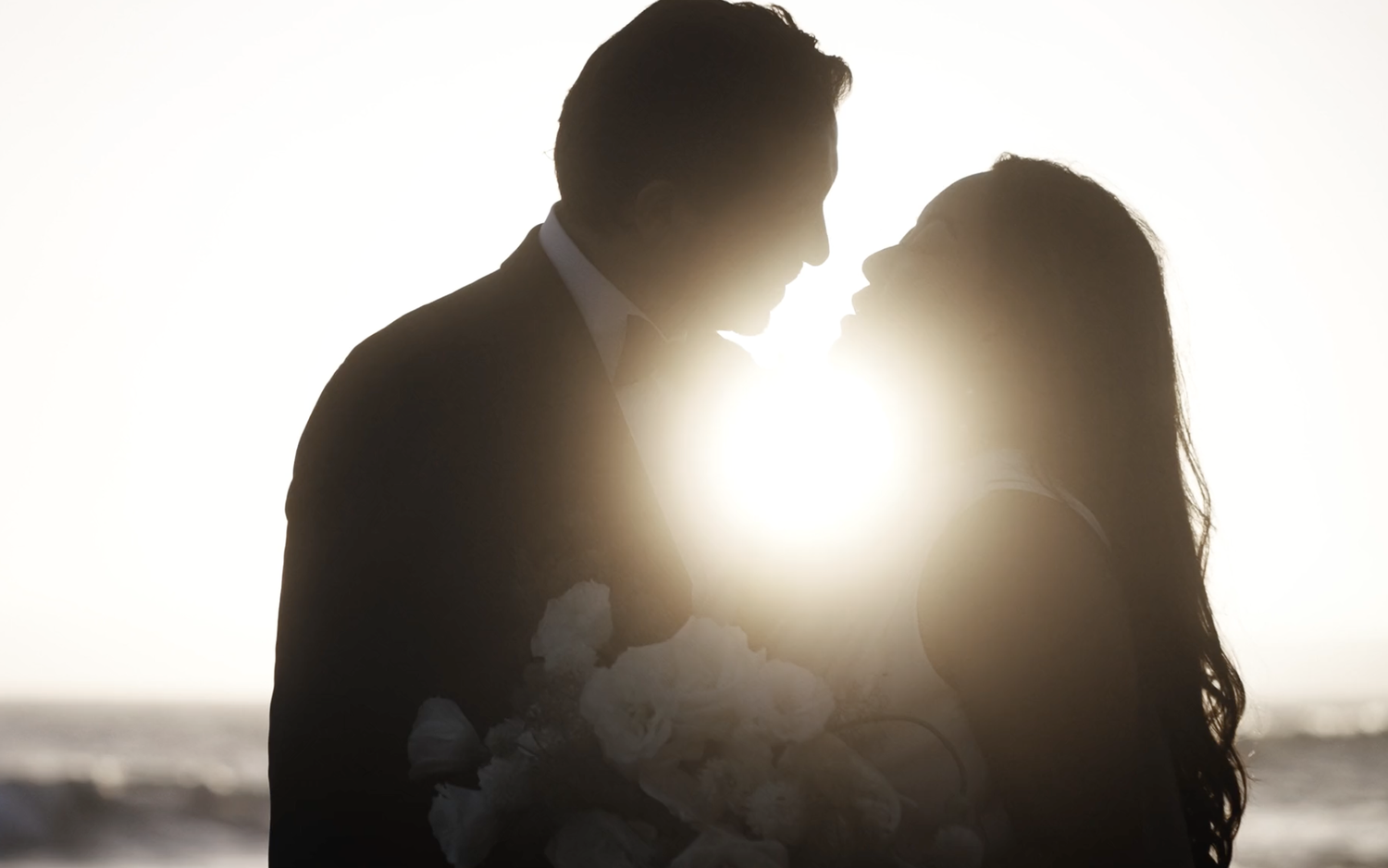 Bride wears Marcela Giocanti gown and kisses groom at sunset