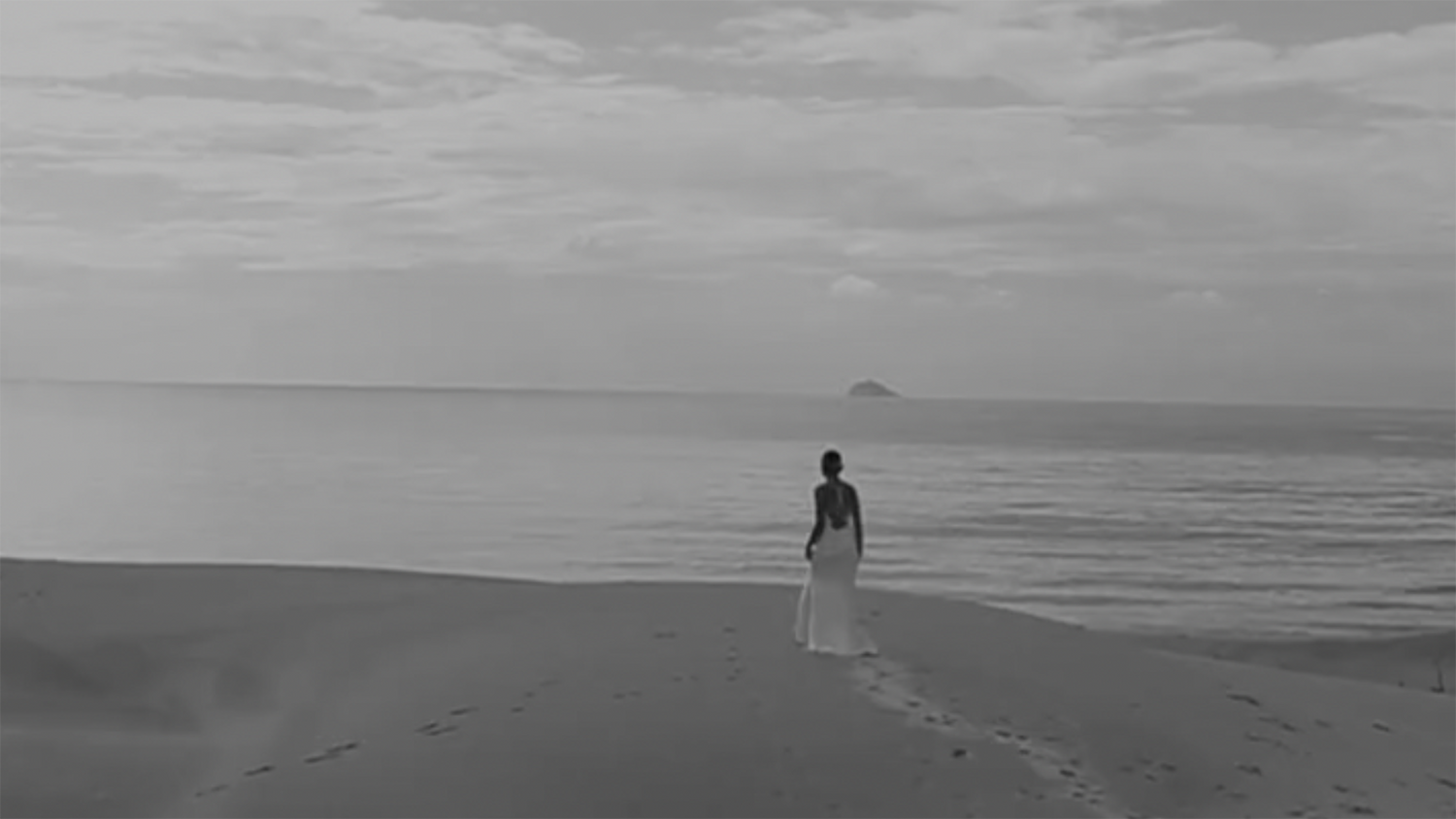 Bride wearing backless wedding dress walking towards the beach
