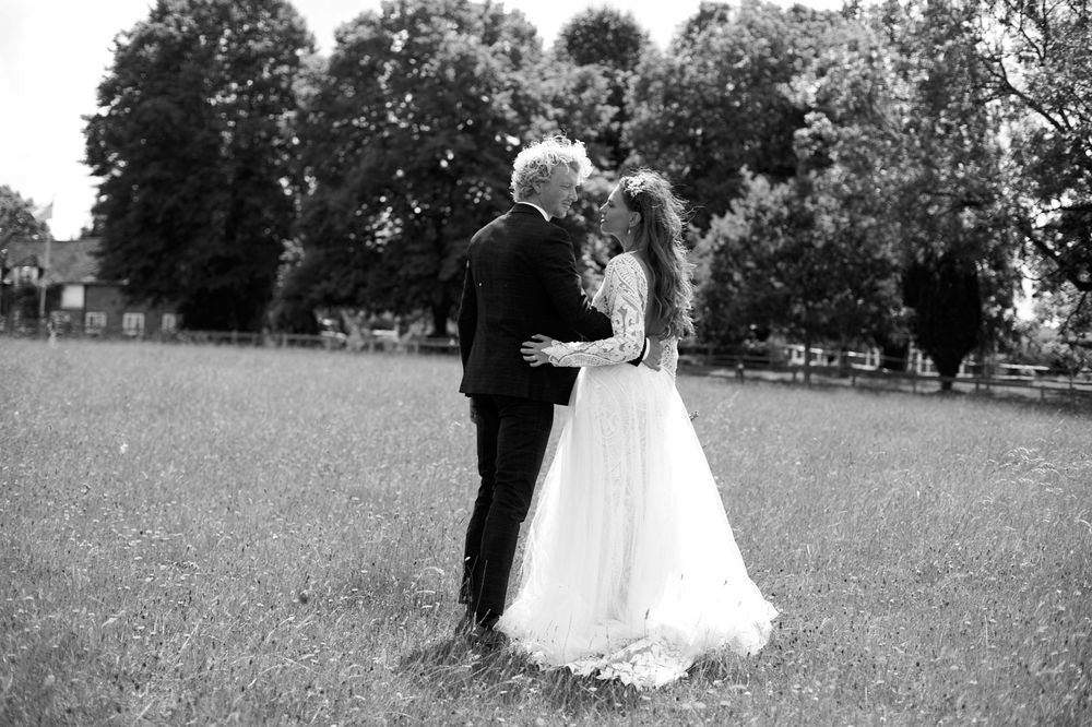 Marcela Giocanti Bride wearing Aniko dress 13015 with groom in a field on wedding day