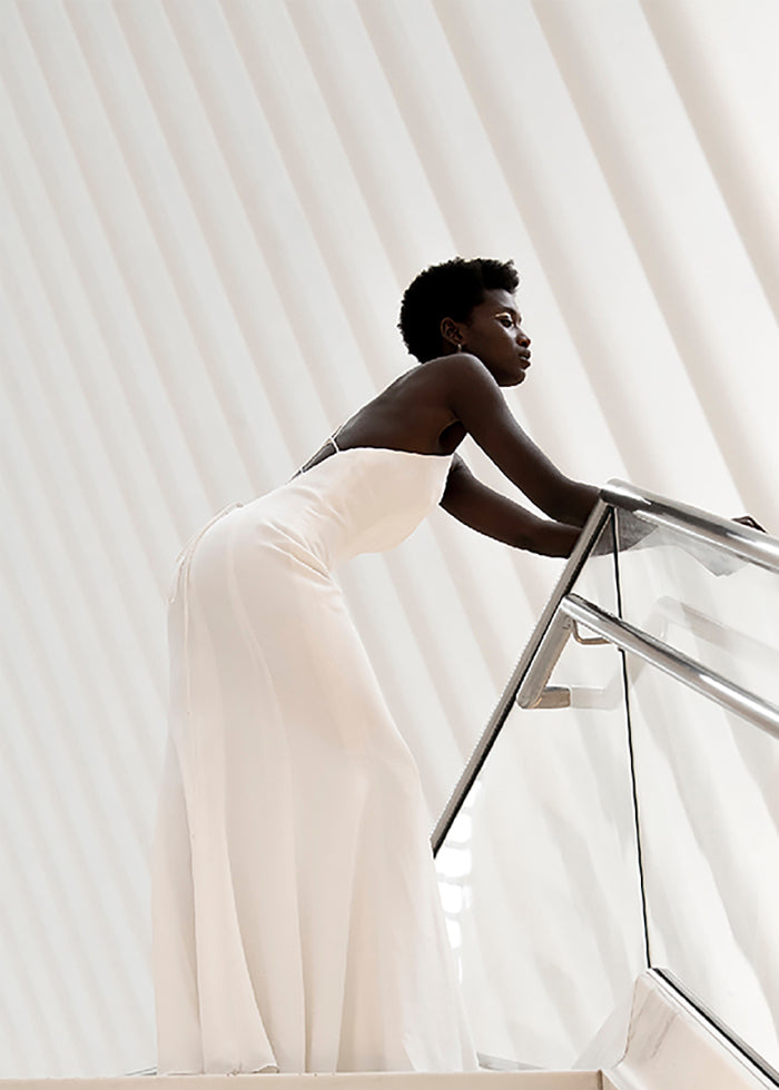 black model wears Clean Stretch Crepe Fit and Flare Wedding Dress overlooking wedding