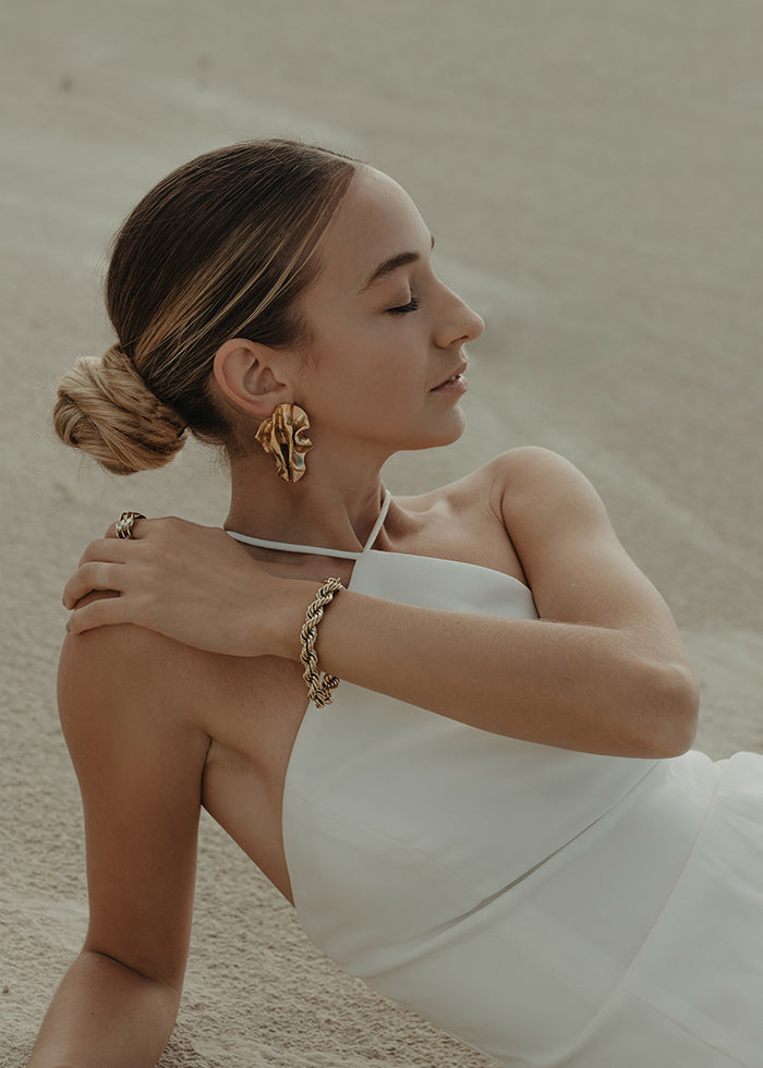 Model lays down wearing  Clean Stretch Crepe Fit and Flare halter neck Wedding Dress