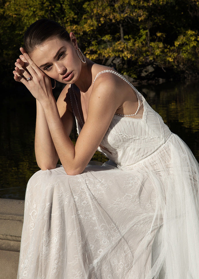 Model wears beaded lace wedding dress designed by best wedding designers