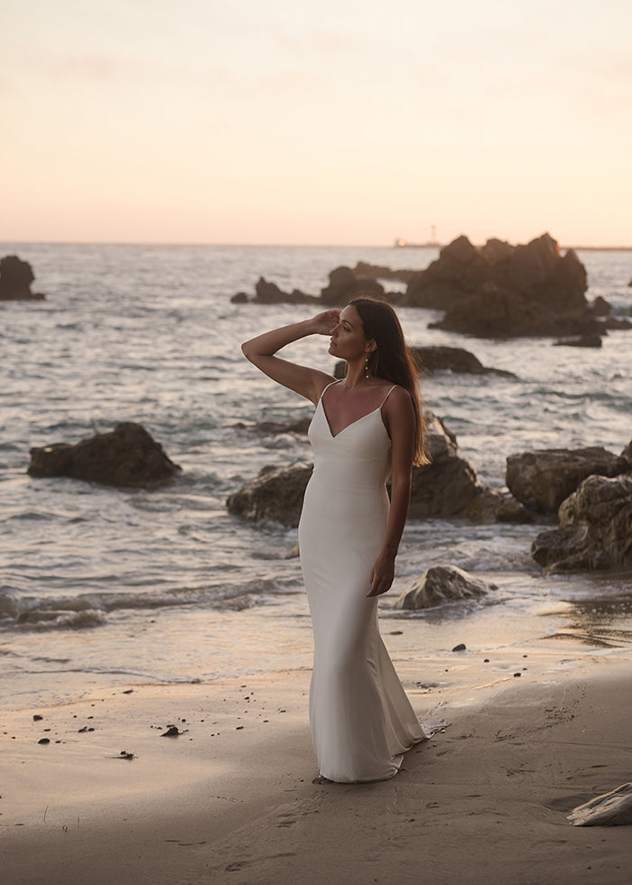 bride wears v-neck spaghetti strap lady fit and flare dress on the beach for outdoor wedding