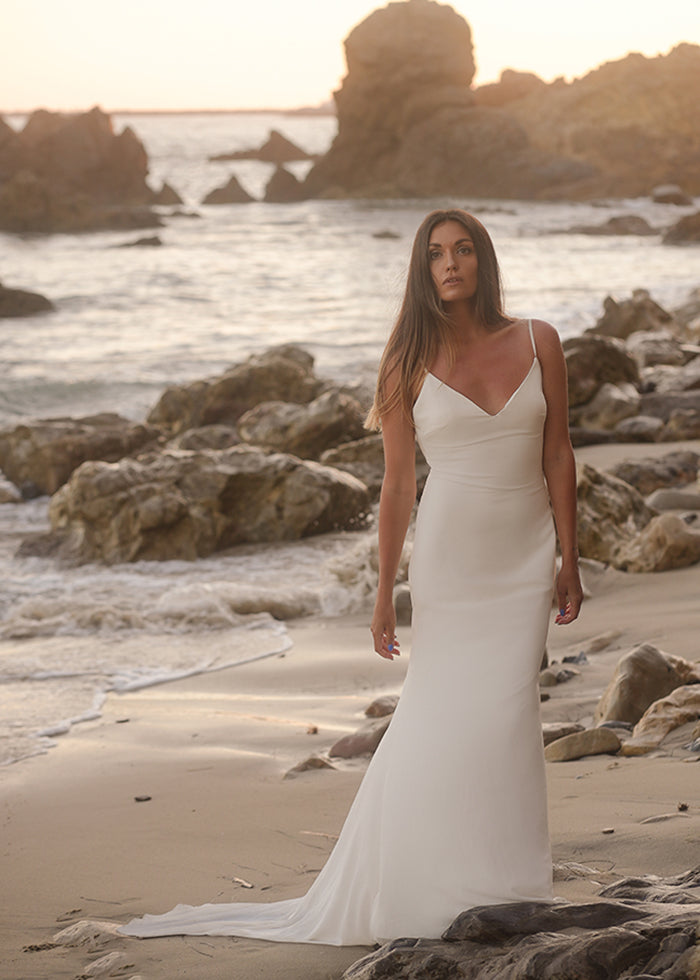 Model wears Ivory v-neck fluted wedding dress custom designed by one of the best wedding designers