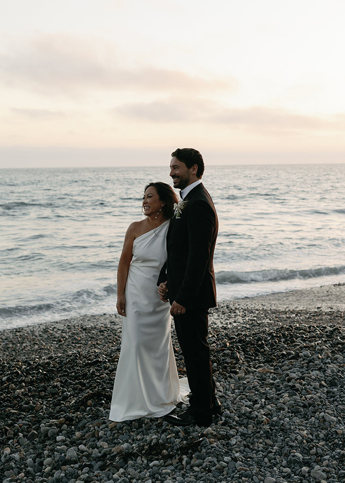 Bride wears one shoulder stretch satin bridal wear on the beach wedding