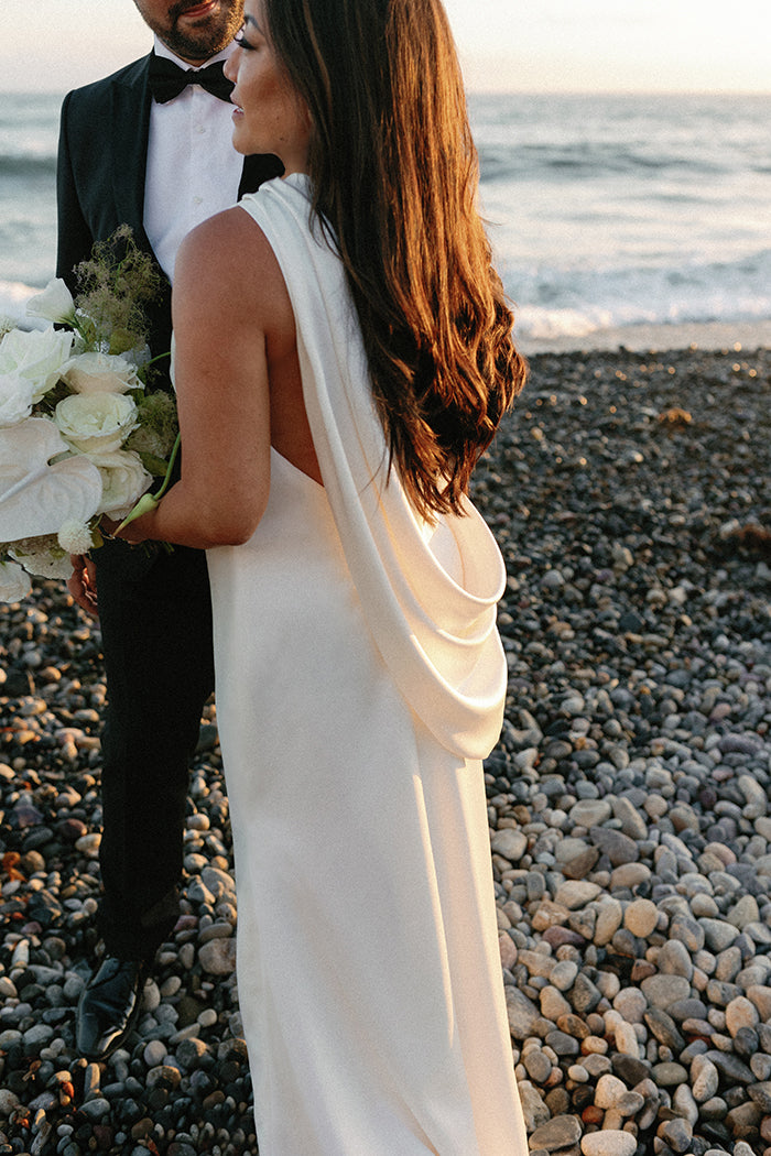 Bride shows off the beautifully draped one shoulder cowl detail and illusion back on her wedding dress 