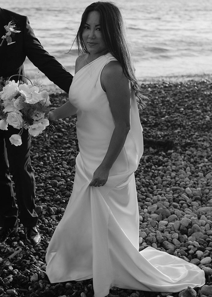 Bride looks stunning in her modern one shoulder elegant romantic wedding dress for the beach