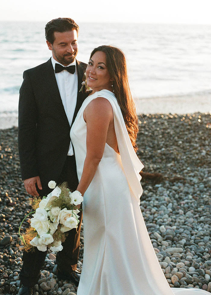 Bride shows off side cowl details of her custom designed wedding dress by best wedding designer in London