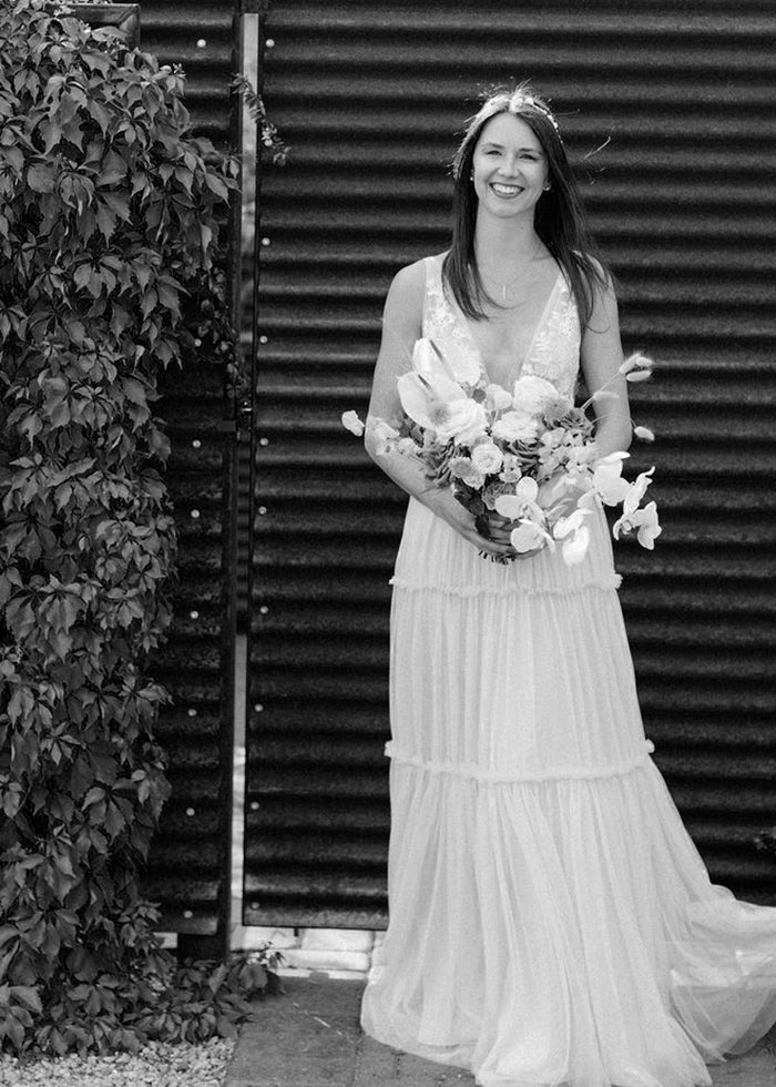 Bride beams wearing her custom made Marcela Giocanti tulle and lace a-line wedding dress