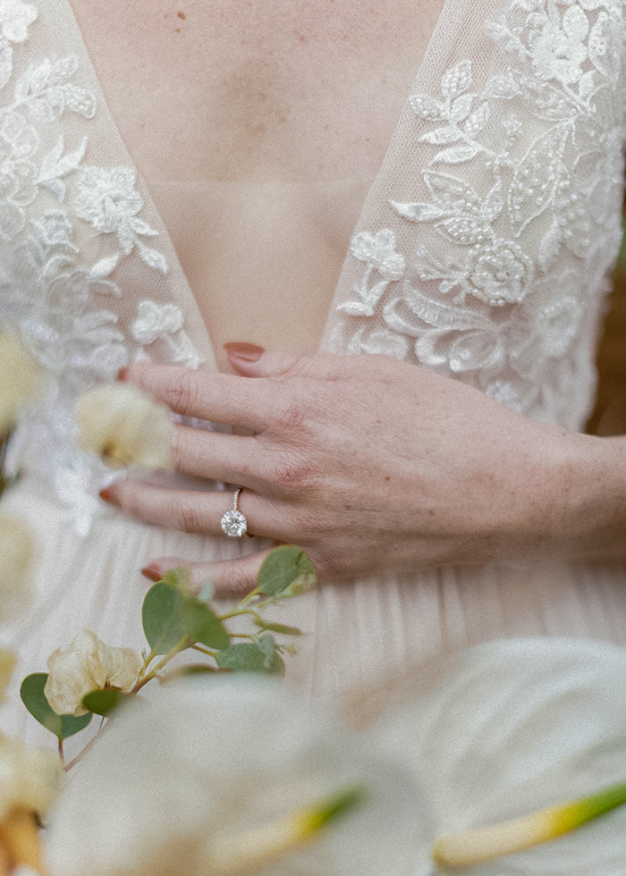 Bride wears V-neckline tulle and beaded lace wedding dress details 