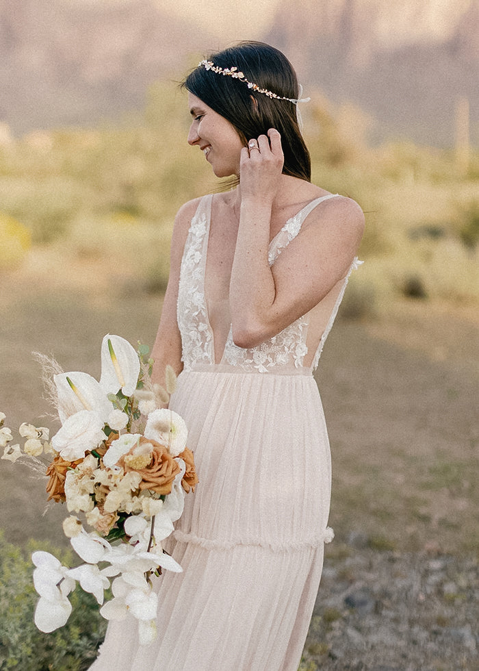 Bride embraces wearing her custom tulle and beaded lace a-line wedding dress bought from bridal wear online shop