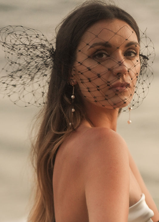 Model wears dramatic cage veil and veil for wedding dress